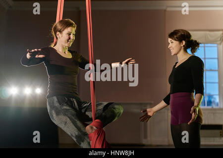 Due giovani donne acrobati antenna praticando equilibrio sulla corda di seta Foto Stock