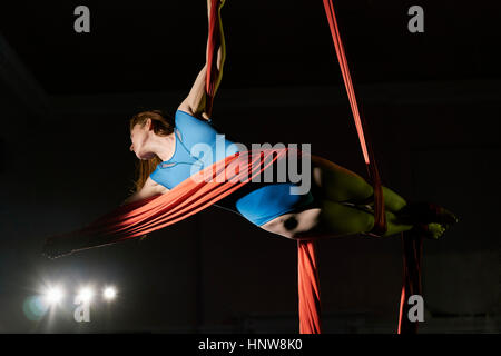 Giovani antenna femmina acrobat avvolto orizzontalmente in corda di seta Foto Stock