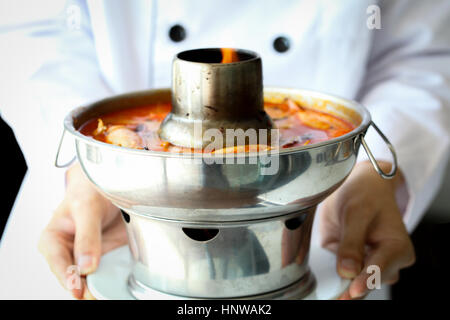 Lo chef è orgogliosa di presentare una zuppa tailandese Tom Yum Goong, famoso Thai cibo piccante Foto Stock