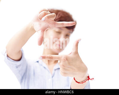 Donna asiatica incorniciare una foto con le mani, isolati su sfondo bianco. Foto Stock