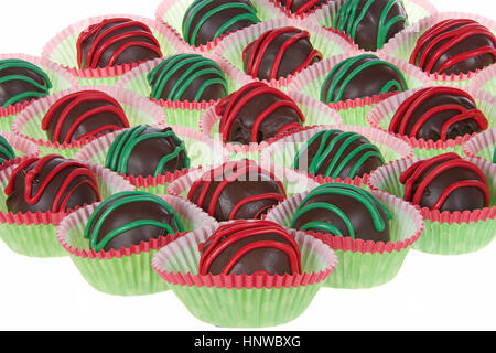 Torta al cioccolato sfere strippato con il rosso e il verde candy fonde per una festa di Natale design vacanze isolati su sfondo bianco Foto Stock