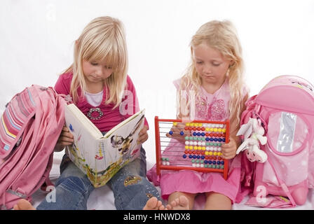 Modello di rilascio, Zwei Schulmaedchen mit Lesebuch und Abakus - due studentesse con libro e abacus Foto Stock