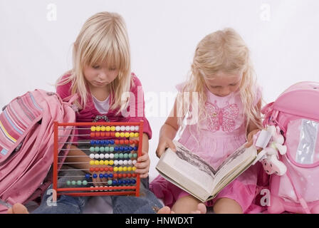 Modello di rilascio, Zwei Scchulmaedchen mit Lesbuch und Abakus - due studentesse con libro e abacus Foto Stock