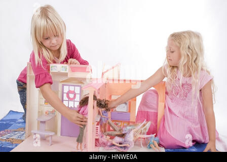 Modello di rilascio, Zwei spielen Maedchen mit Puppenhaus - due ragazza che gioca con la casa dei burattini Foto Stock