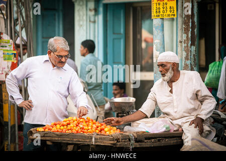 Delhi, India - 18 Settembre 2014: Indiano uomo comprando i pomodori dal fornitore musulmana sulla strada della Vecchia Delhi, India il 18 settembre 2014. Foto Stock