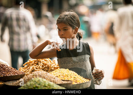 Rishikesh, India - settembre 23,2014: ragazza indiana acquistare dolci della bancarella di strada a Rishikesh, India il 23 settembre, 2014 Foto Stock