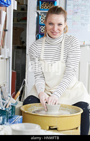 Donna che lavorano a ruota di ceramiche in Studio Foto Stock