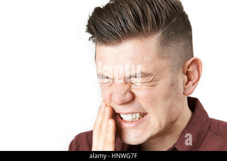 Ritratto in studio di uomo che soffre di mal di denti Foto Stock