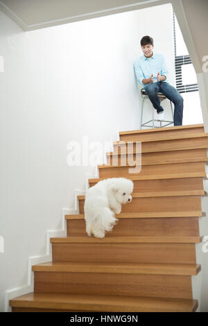 Uomo sorridente chiamando il suo cane Foto Stock