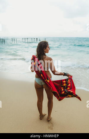 Vista posteriore della donna sulla spiaggia essiccando con asciugamano, Oahu, Hawaii, STATI UNITI D'AMERICA Foto Stock