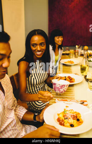 Gruppo di amici al tavolo da pranzo Foto Stock