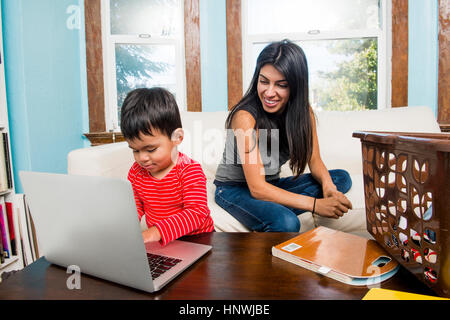 Bimbi maschio con la madre la digitazione sul portatile a casa Foto Stock