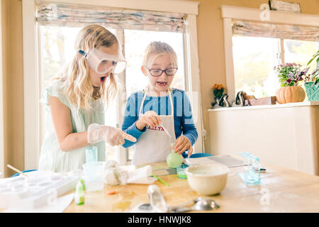 Due ragazze sorpreso fare scienza esperimento, puntamento Foto Stock