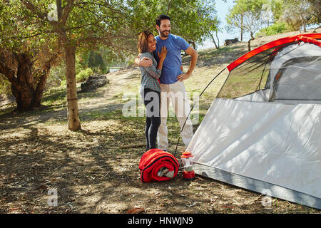 Metà adulto giovane camping, ammirando la loro tenda Foto Stock