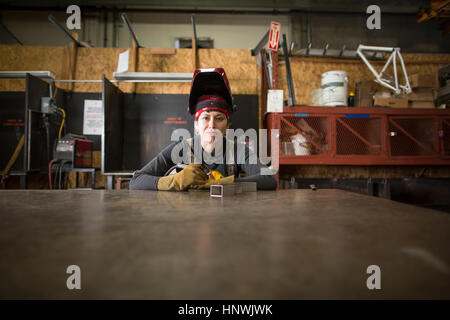 Ritratto di donna metalsmith al banco di officina Foto Stock