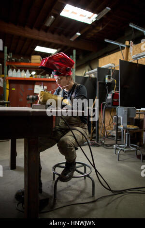 Metalsmith femmina la preparazione di aste metalliche a banco di officina Foto Stock