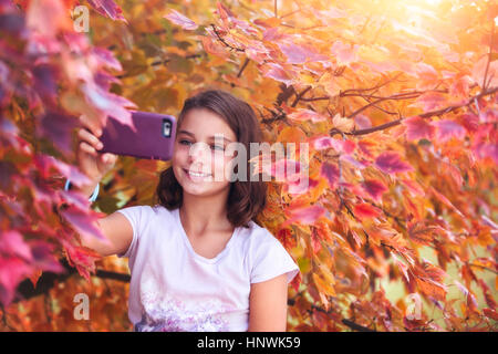 Giovane ragazza in ambiente rurale, tenendo selfie con lo smartphone Foto Stock