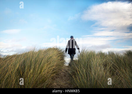 Donna che cammina sulle dune Foto Stock