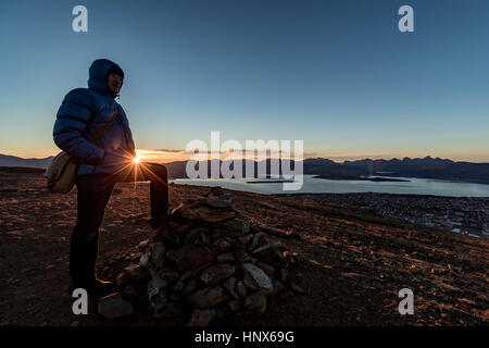 L'uomo salendo un vertice vicino a Tromso in autunno, Arctic Norvegia Foto Stock