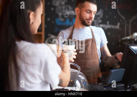 Barista utilizzando un registratore di cassa Foto Stock