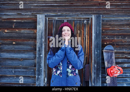 Ritratto di donna in knit hat la pratica dello yoga con le mani insieme da log cabin Foto Stock