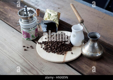 I chicchi di caffè, una smerigliatrice POT del caffè sul tavolo in legno Foto Stock