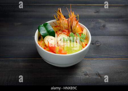 Tom Yum o zuppa di gamberi di fiume piccante minestra acida (Tom Yum Goong) sul tavolo di legno, Tailandese cibo locale Foto Stock