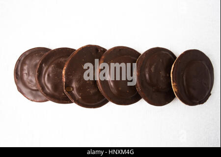 Vista dall'alto di diversi ricoperta di cioccolato snack dolci su uno sfondo bianco. Foto Stock