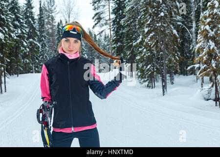 Sci di fondo donna classica facendo Nordic sci di fondo nel sentiero tracce nella neve coperto foresta Foto Stock