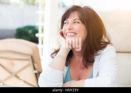 Attraente donna di mezza età sorrisi sul patio. Foto Stock