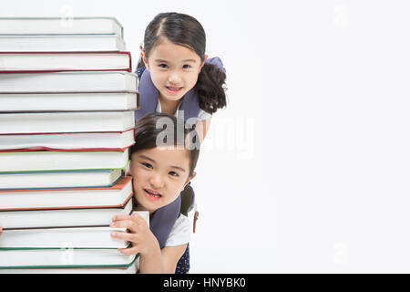 Ritratto di sorridere due gemelle con libri impilati Foto Stock