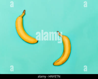 Le due banane contro sfondo blu Foto Stock