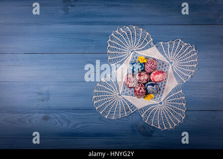 Gruppo di dipinti a mano le uova di pasqua sul blu superficie in legno Foto Stock