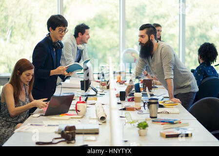 I colleghi che lavorano insieme in un piano aperto office Foto Stock