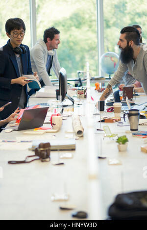 I colleghi che lavorano insieme in un piano aperto office Foto Stock