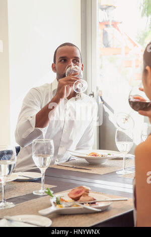 L uomo beve il vino al ristorante Foto Stock