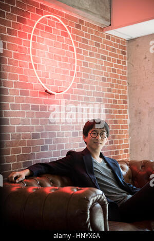 Uomo seduto sul divano, ritratto Foto Stock
