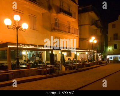 La Corsica, Francia: Gioco di bocce serata di fronte ad un tipico ristorante nel centro storico Foto Stock