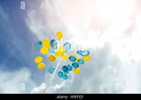 Bouquet di blu e giallo palloncini nel cielo Foto Stock