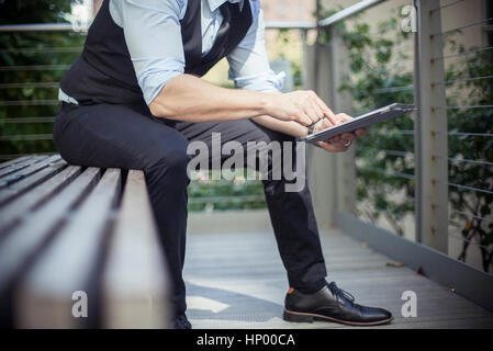 Uomo con tavoletta digitale all'aperto, ritagliato Foto Stock