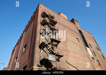 Metallo vecchio fire escape sul lato di Red Brick Warehouse edificio Dock Liverpool Regno Unito Foto Stock