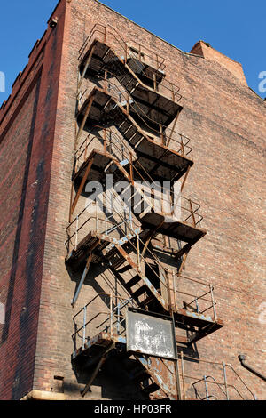 Metallo vecchio fire escape sul lato di Red Brick Warehouse edificio Dock Liverpool Regno Unito Foto Stock