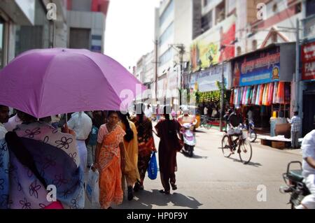 Usando un ombrello come un ombrellone nel caldo sole su un Indiano street, Thanjavur ( Tanjore) in Tamil Nadu, nell India meridionale Foto Stock