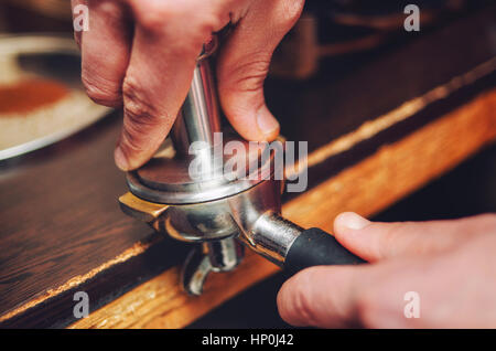 Close-up di una mano versa del caffè baristi del titolare. Soft focus Foto Stock