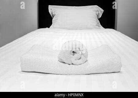 Singola letto preparato con il bianco montato in foglio laminato e asciugamani in attesa per gli ospiti in una sistemazione di lusso in camera da letto. Foto Stock