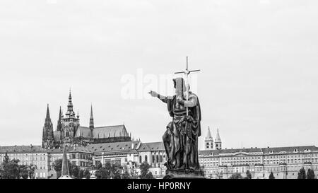 La città di Praga in monocromia con la statua del Ponte Carlo in primo piano Foto Stock