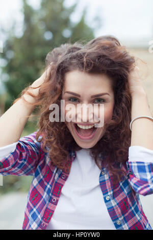 Spensierato giovane donna ridendo all'aperto, ritratto Foto Stock