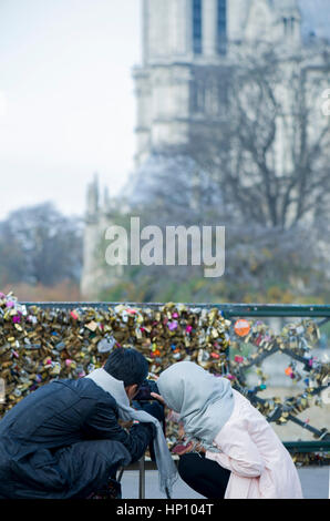 Giovane fotografa l amore si blocca a Pont des Arts, Parigi, Francia Foto Stock