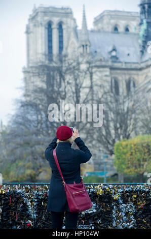 Tourist fotografare la Cattedrale di Notre Dame da Pont des Arts, Parigi, Francia Foto Stock