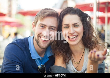 Coppia giovane ridere insieme all'aperto, ritratto Foto Stock